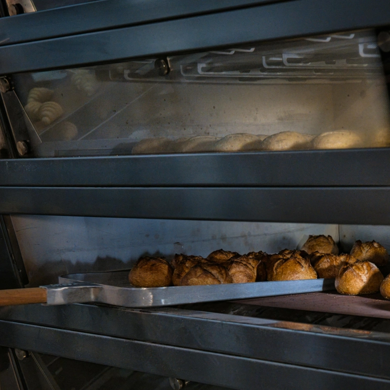 Forno di un panificio con pala che rimuove del pane pronto.