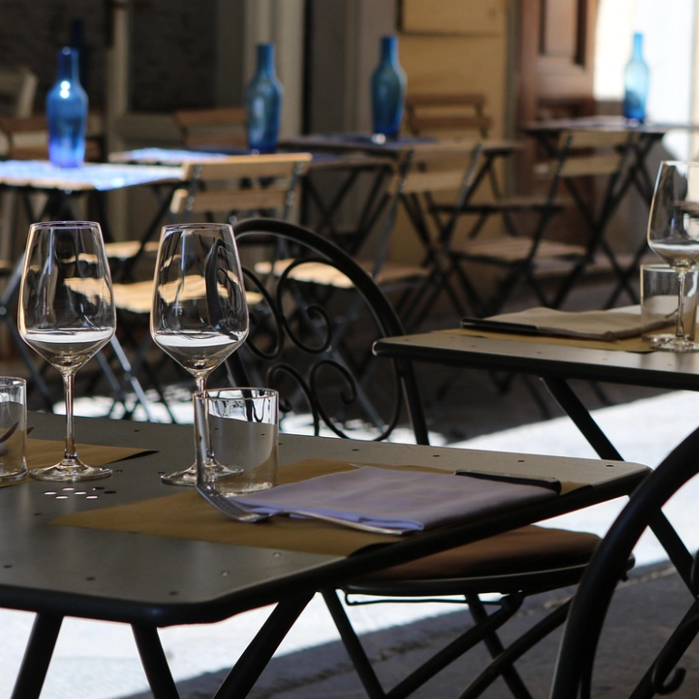 Tavoli di un ristorante all'aperto con i suoi peculiari rischi da analizzare per la redazione del DVR.