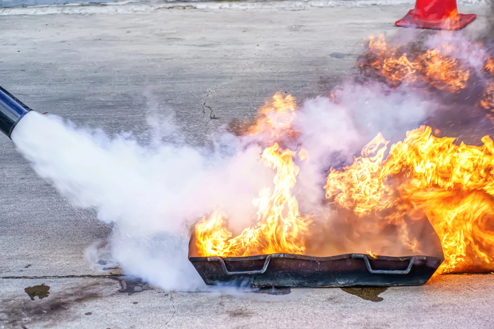 Esercitazione del corso antincendio con estintore usato per spegnere fiamme controllate