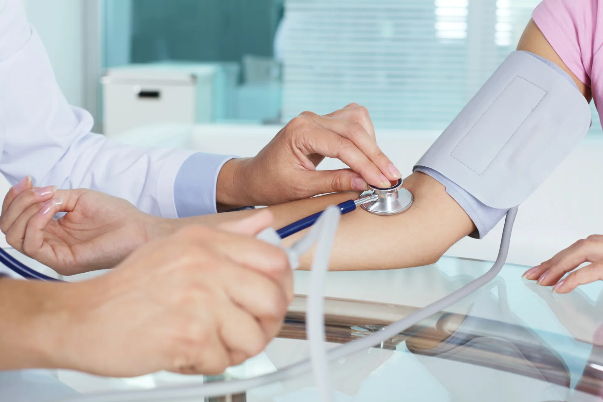 Medico controlla il battito sul braccio di una cameriera tramite stetoscopio nel contesto di una visita medica aziendale obbligatoria per ristoranti
